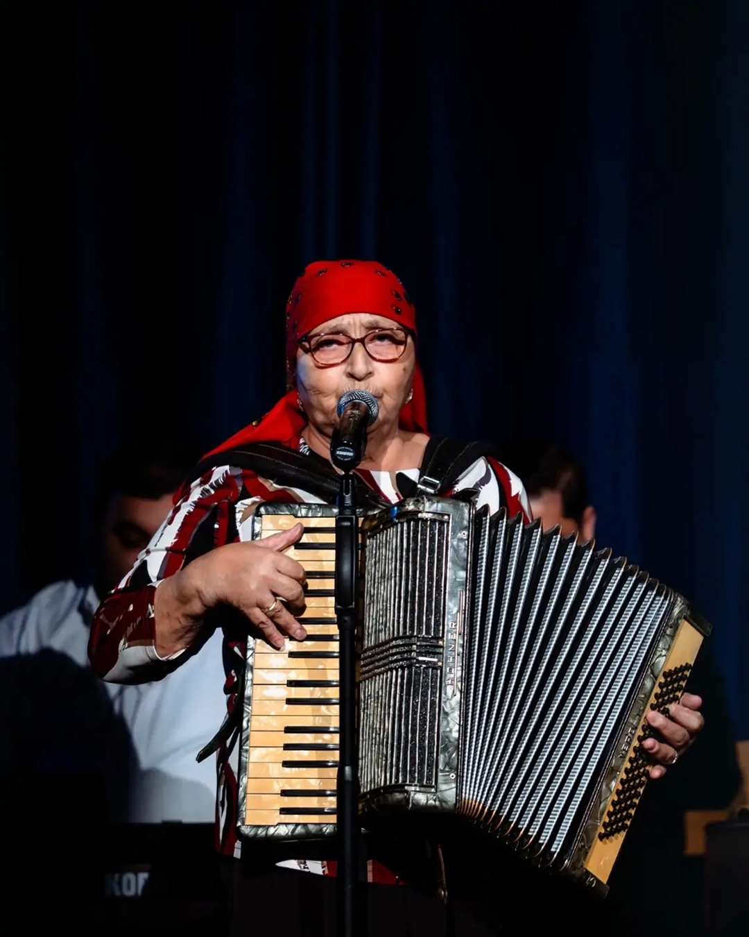 Cântăreața Tarafului de la Vărbilău, cu basma roșie și acordeon, în concert